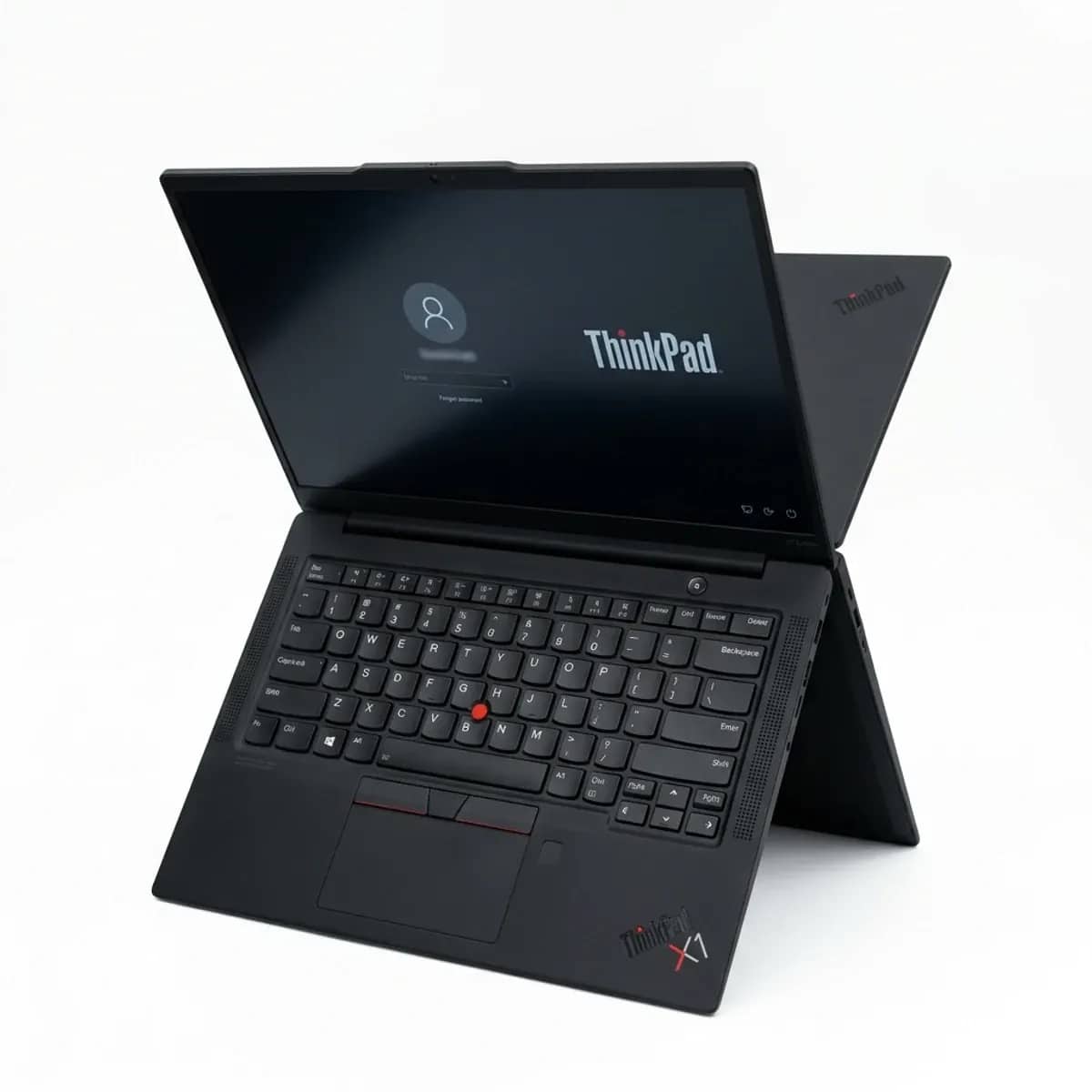 A ThinkPad X1 Carbon open, red TrackPoint visible